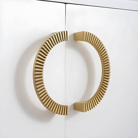 A polished brass semi-circle handle mounted on a white door.